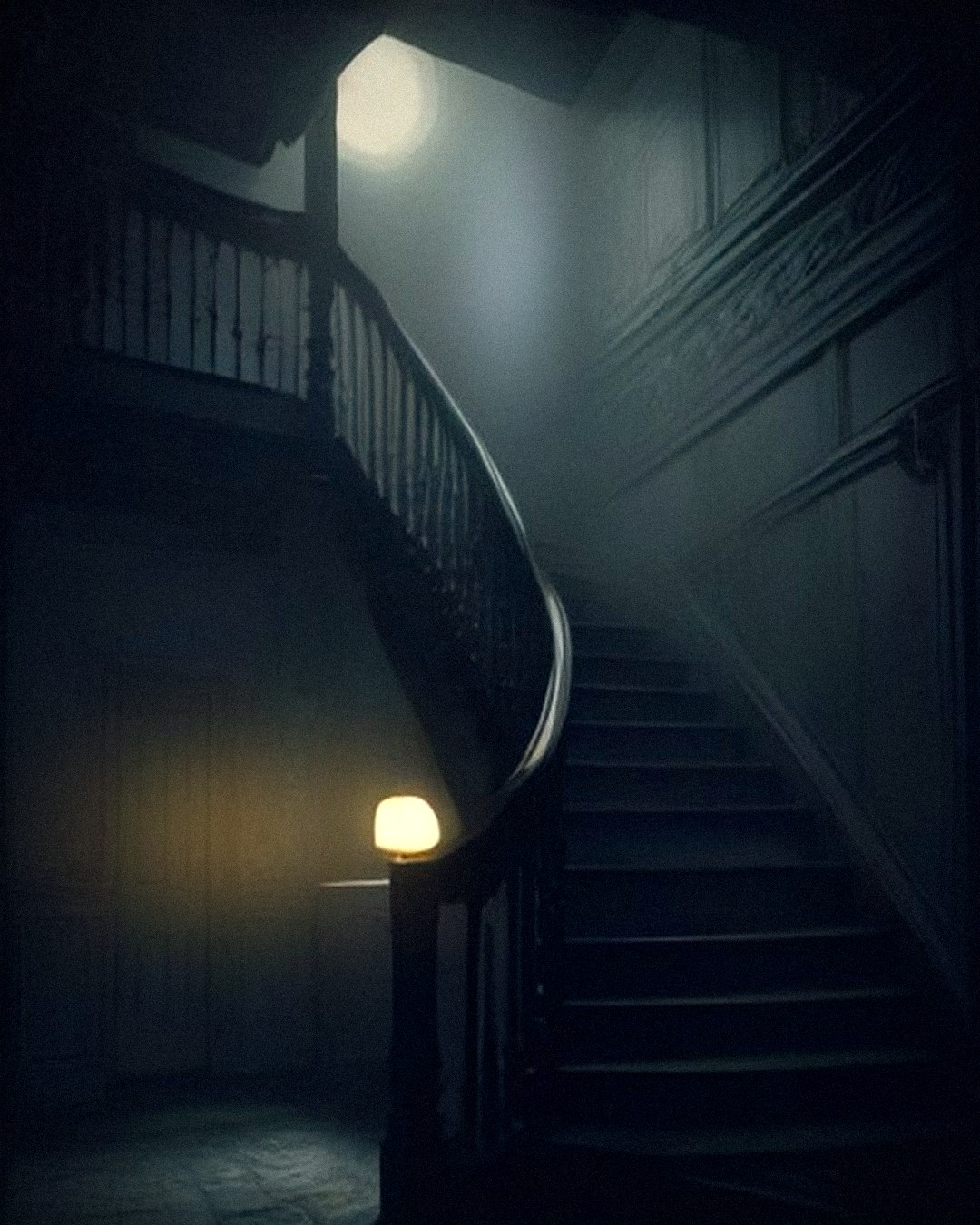 Curving staircase of an old haunted house in moonlit mist, a single lamp glowing at the foot of the stairs